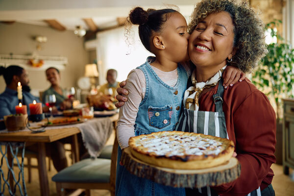 Photo of a mother and daughter holding a Thanksgiving pie 