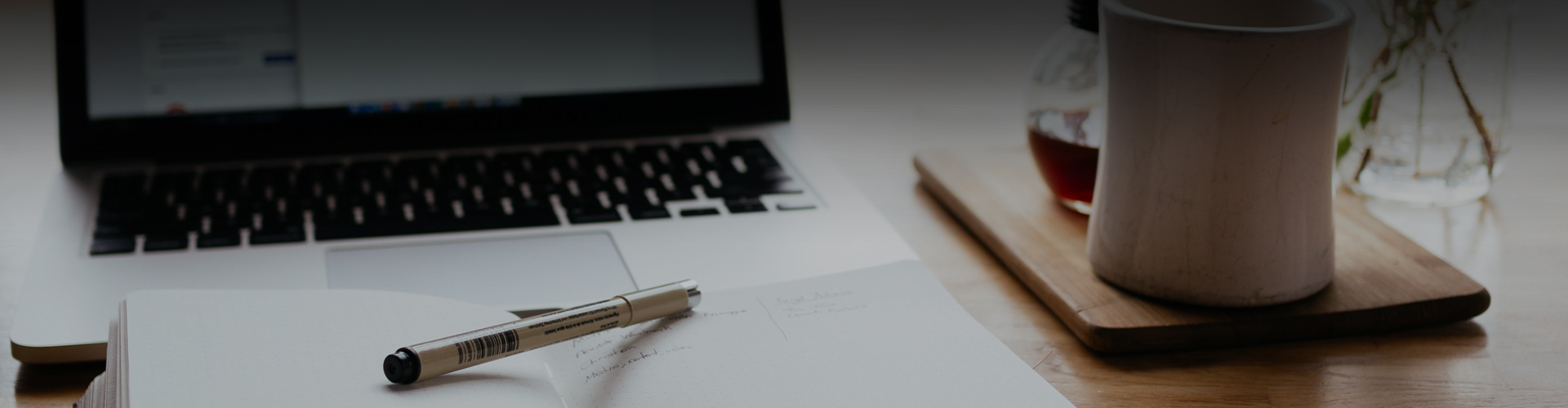 Closeup photo of pens and a laptop