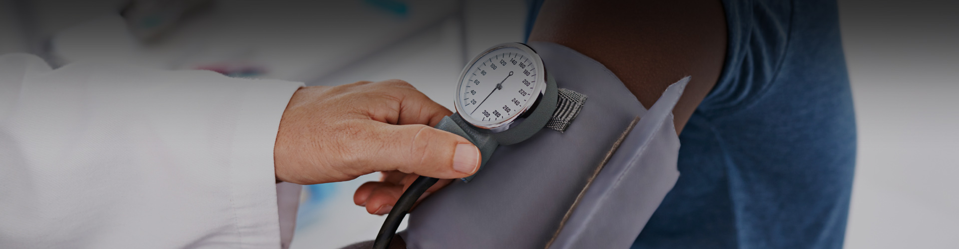 Photo of a doctor checking a patient's blood pressure