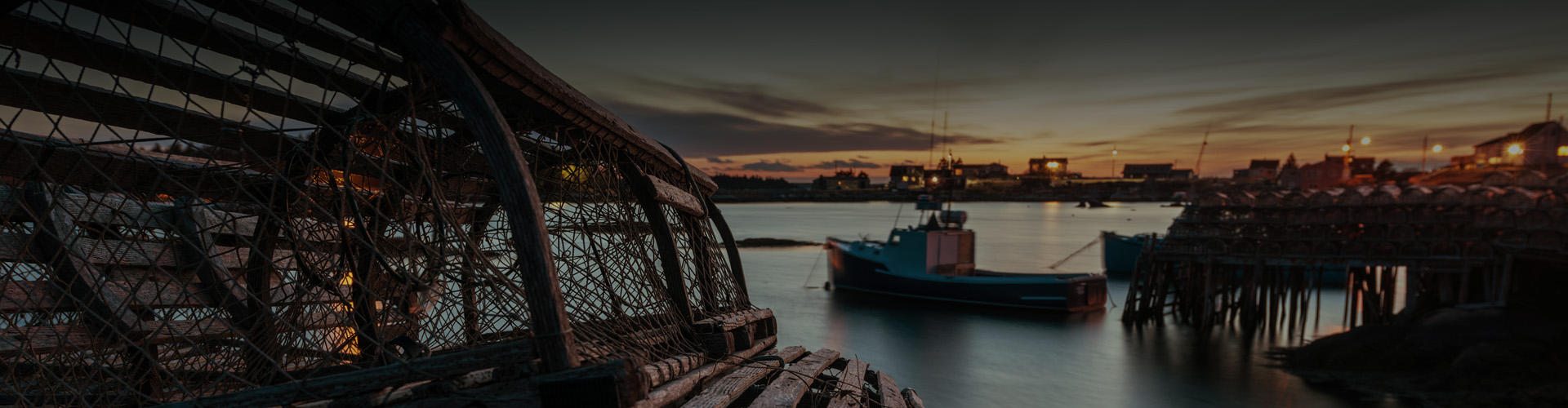 Photo of a lobster pot with fishing boats in the background