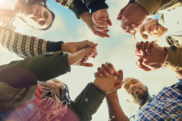 Photo of group of solemn people holding hands