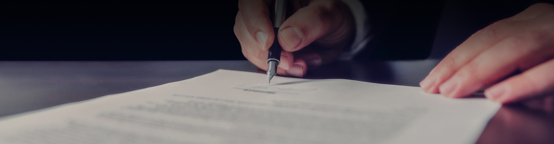 Closeup photo of person signing a legal document
