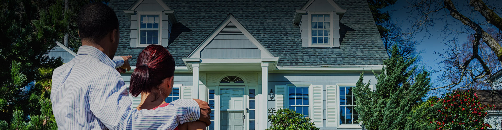 Photo of a couple looking at the front of a house