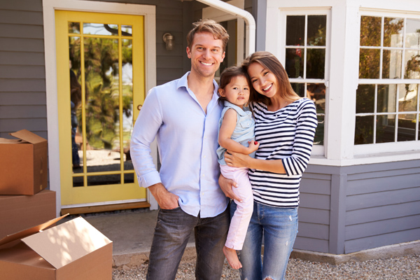 Photo of happy family in front of their new home