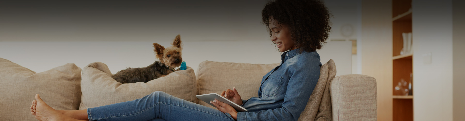 Photo of a woman looking at her tablet on a couch