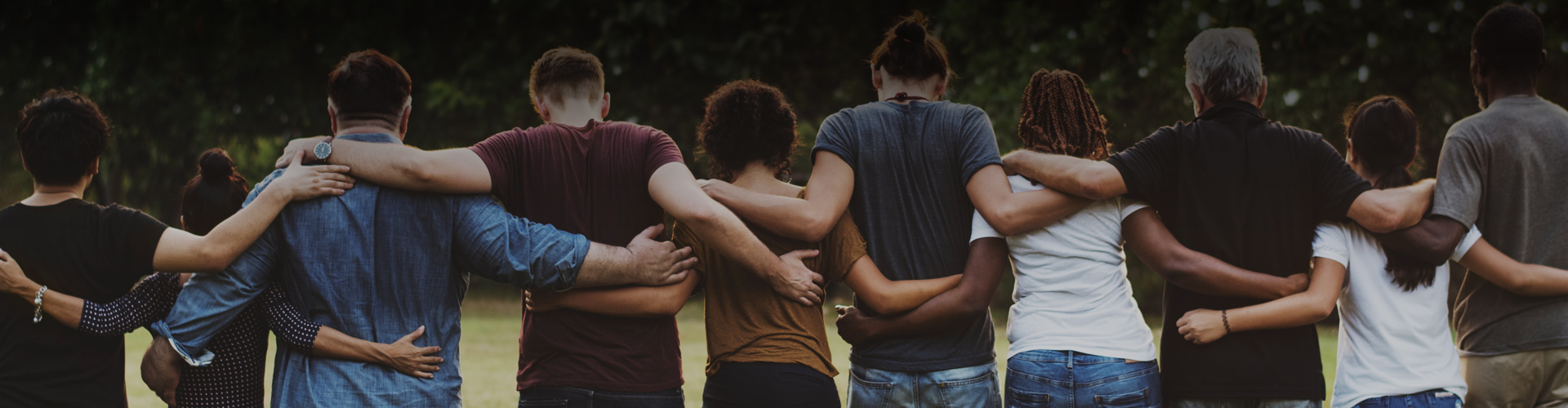 Photo of a group of people with their arms around each other