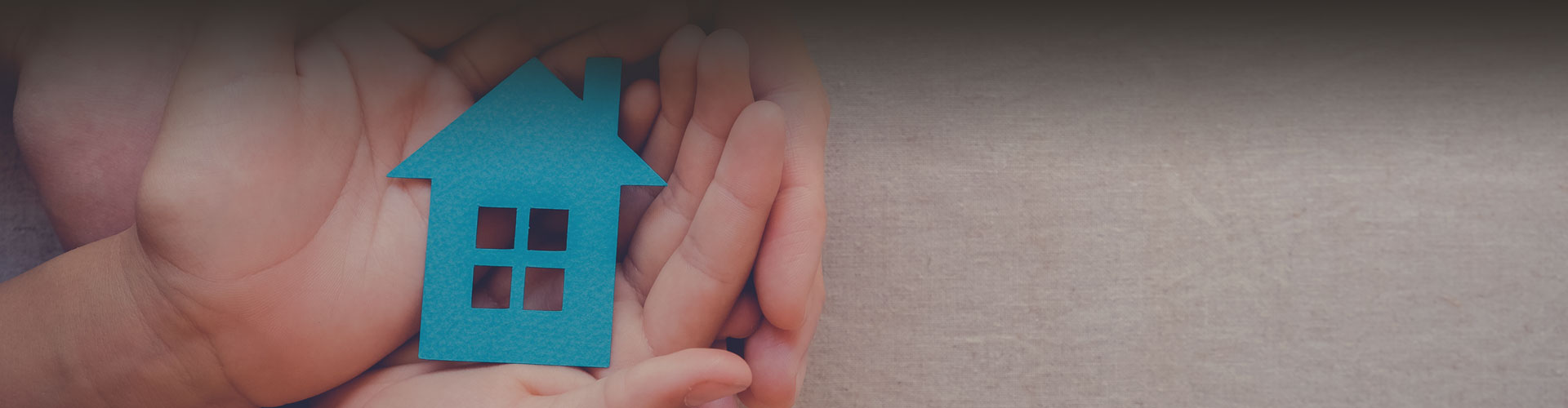 Closeup photo of hands holding a paper cutout of a house