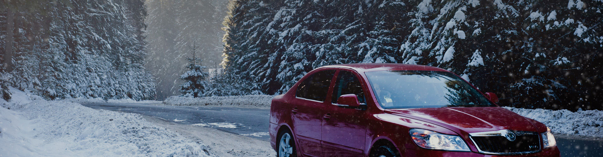 A photo of a car on a snowy roadway, demonstrating the importance of having car insurance in Maine