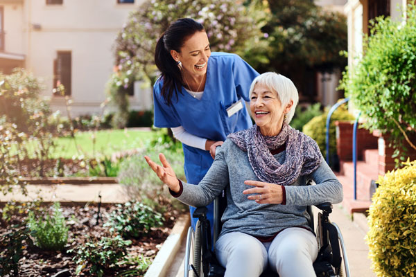 Photo of a caregiver and an elderly client in a wheelchair