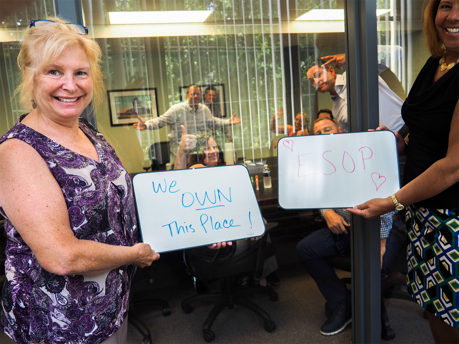 Photo of Clark Insurance Manchester employees holding up whiteboards with fun encouraging messages