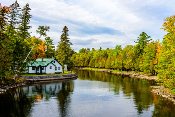 Image of a house next to a forested lake