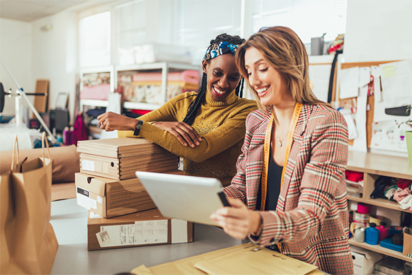 A photo of two woman smiling with boxes