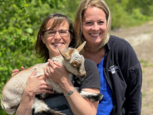 Photo of two Clark employees holding a baby goat