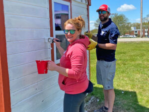 Image of two Clark Insurance employees painting a house as volunteers