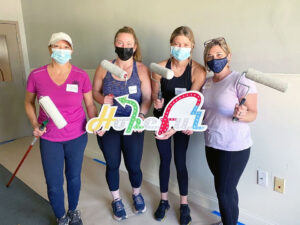 Image of two Clark Insurance employees painting a house interior as volunteers